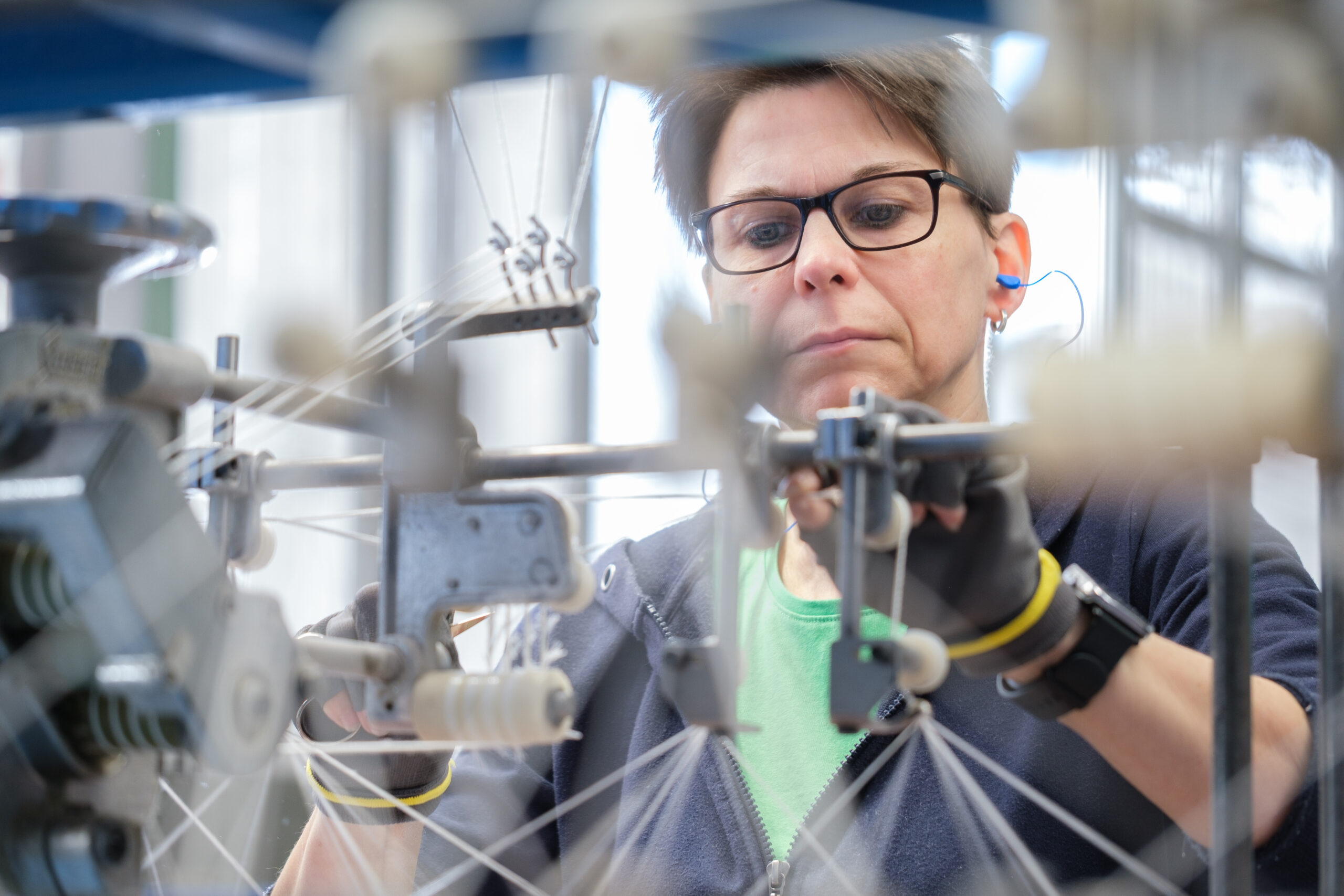 Fachkraft der Fa. Dochtfabrik Wedo Nettetal Fachkraft an einer Dochtspinnereimaschine