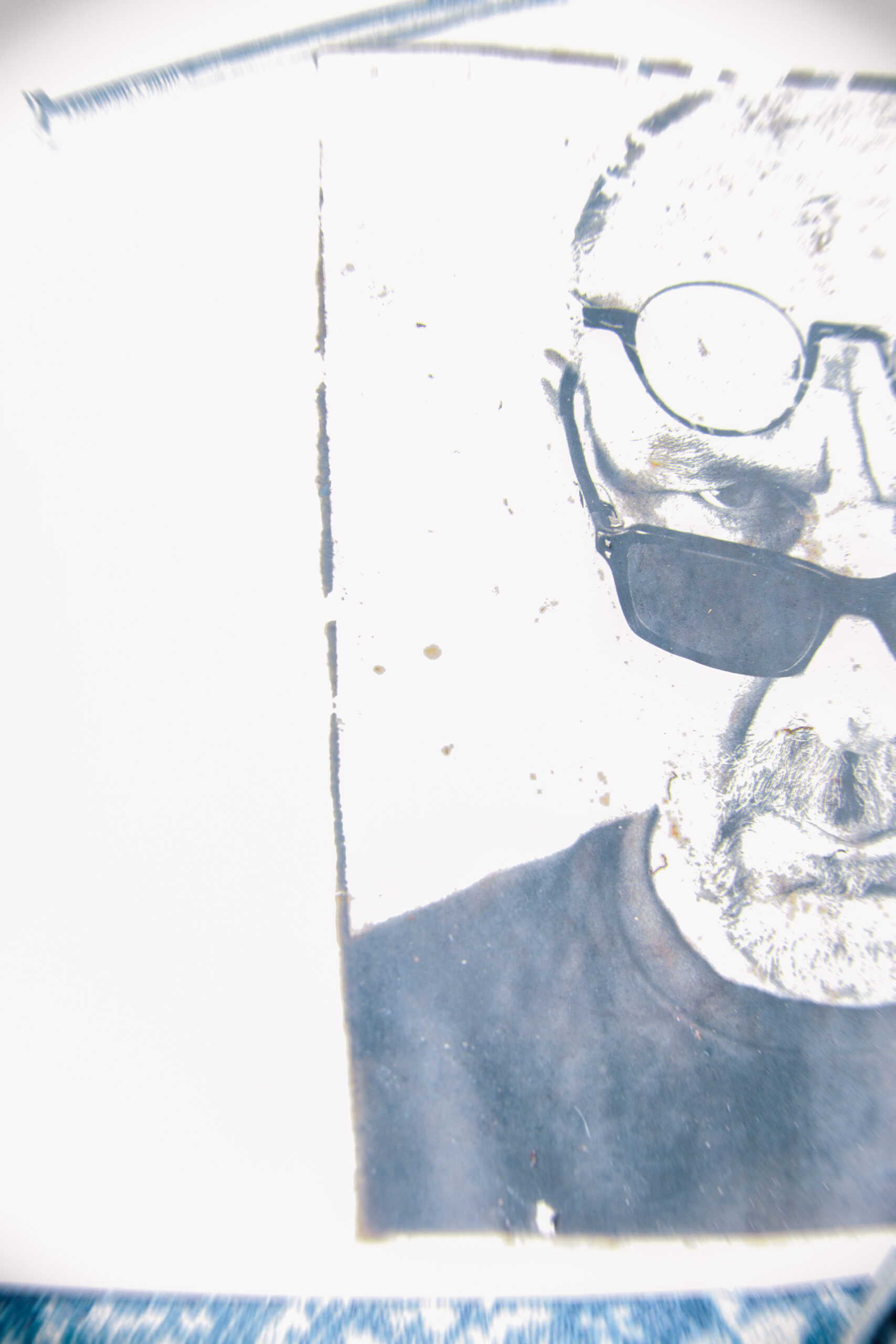Auf der Suche nach Erkenntnis stark bearbeitetes Gesichtsportrait eines Mannes, nur die rechte Hälfte ist zu sehen, er trägt eine Brille über und eine unter dem Auge